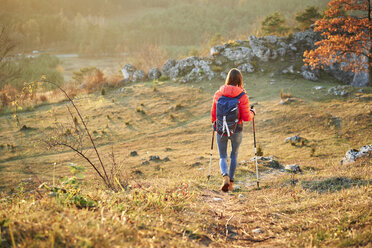 Rückansicht einer Frau auf einem Wanderweg in den Bergen - BSZF00982