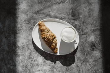 Cup of white coffee and a whole meal croissant on plate - AFVF02352