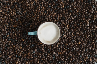Tasse Milchkaffee zwischen Kaffeebohnen - AFVF02380