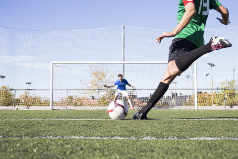 Fußballspieler schießt den Ball auf dem Fußballfeld, lizenzfreies Stockfoto