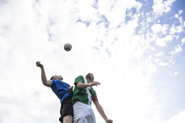 Fußballspieler, die während eines Fußballspiels den Ball köpfen wollen - ABZF02193