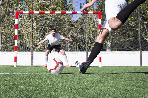 Fußballspieler schießt den Ball auf dem Fußballfeld, lizenzfreies Stockfoto