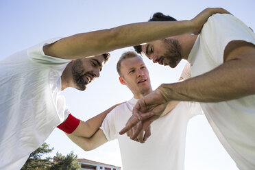 Football players discussing strategy on football field - ABZF02210