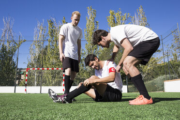 Fußballspieler helfen einem verletzten Spieler während eines Spiels - ABZF02213