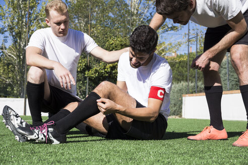 Fußballspieler helfen einem verletzten Spieler während eines Spiels - ABZF02214