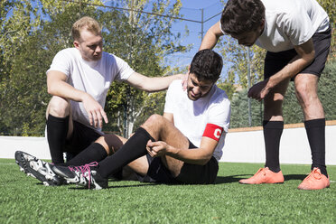 Fußballspieler helfen einem verletzten Spieler während eines Spiels - ABZF02215