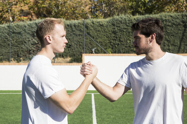 Zwei Fußballspieler schütteln sich auf dem Fußballplatz die Hände - ABZF02219