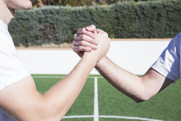 Nahaufnahme von zwei Fußballspielern beim Händeschütteln auf dem Fußballplatz - ABZF02220