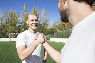 Zwei Fußballspieler schütteln sich auf dem Fußballplatz die Hände - ABZF02222