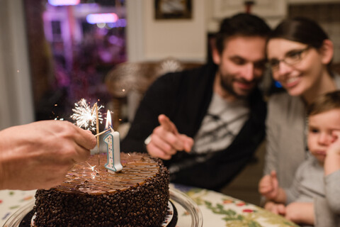 Ehepaar und kleiner Junge mit Kuchen zum ersten Geburtstag, lizenzfreies Stockfoto