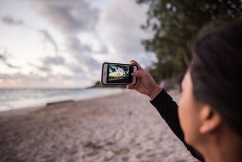 Frau beim Fotografieren am Strand von Kailua, Oahu, Hawaii - ISF20689