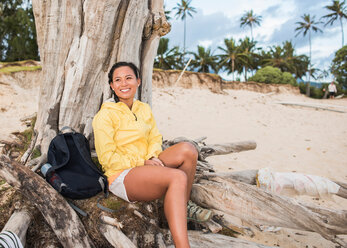 Frau entspannt sich an einem alten Baumstamm, Kailua Beach, Oahu, Hawaii - ISF20690