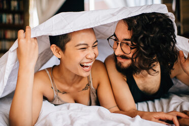 Glückliches Paar unter der Decke im Bett - ISF20705