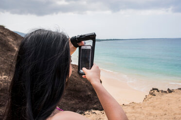 Woman taking photo on beach, Makena Beach, Maui, Hawaii - ISF20777