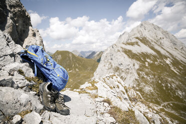Austria, Tyrol, backpack and hiking boots in mountainscape - FKF03257