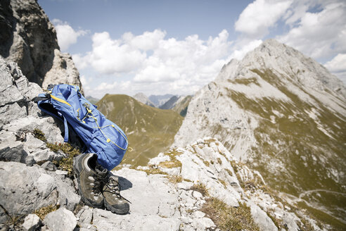 Österreich, Tirol, Rucksack und Wanderschuhe in Berglandschaft - FKF03257