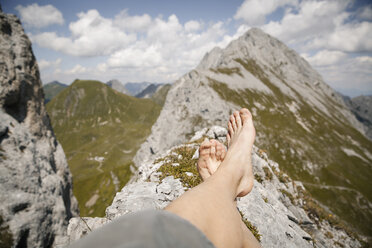 Österreich, Tirol, Blickwinkel auf die Beine eines Mannes in einer Berglandschaft - FKF03258