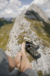 Österreich, Tirol, Blickwinkel auf die Beine eines Mannes in einer Berglandschaft - FKF03260