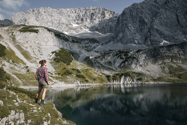 Austria, Tyrol, woman standing at lake Drachensee looking at view - FKF03278