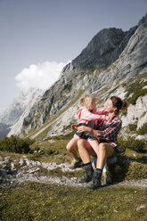 Österreich, Tirol, glückliche Mutter mit Tochter beim Ausruhen in einer Berglandschaft - FKF03280