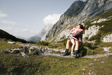 Austria, Tyrol, happy mother and daughter hugging in mountainscape - FKF03282