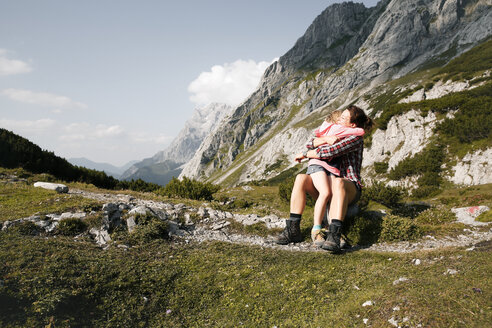 Österreich, Tirol, glückliche Mutter und Tochter umarmen sich in einer Berglandschaft - FKF03282