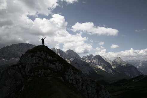 Österreich, Tirol, Silhouette eines jubelnden Mannes auf einem Berggipfel - FKF03293