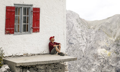 Österreich, Tirol, Mann auf Wandertour rastet auf einer Berghütte - FKF03308