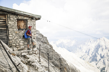 Österreich, Tirol, Mann beim Wandern auf einer Berghütte - FKF03313