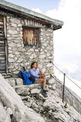 Austria, Tyrol, woman on a hiking trip resting at mountain hut - FKF03314