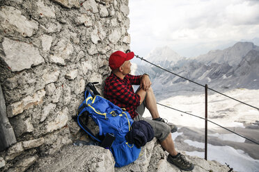 Österreich, Tirol, Mann auf Wandertour rastet auf einer Berghütte und betrachtet die Aussicht - FKF03320