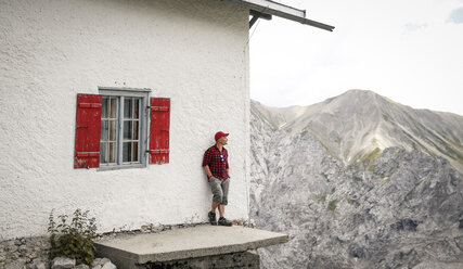 Österreich, Tirol, Mann beim Wandern auf einer Berghütte - FKF03325