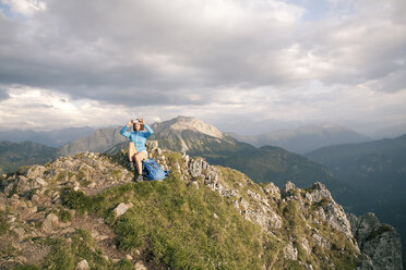 Österreich, Tirol, Frau beim Wandern in den Bergen, Handyfoto auf dem Gipfel - FKF03330