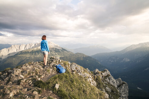 Österreich, Tirol, Frau beim Wandern in den Bergen auf dem Gipfel stehend - FKF03334