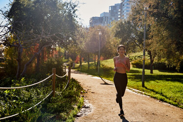 Woman jogging in city park, Barcelona, Catalonia, Spain - ISF20867