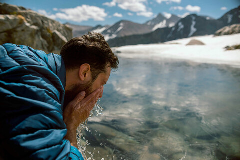 Wanderer erfrischt sich am See, Mineral King, Kalifornien, Vereinigte Staaten, lizenzfreies Stockfoto
