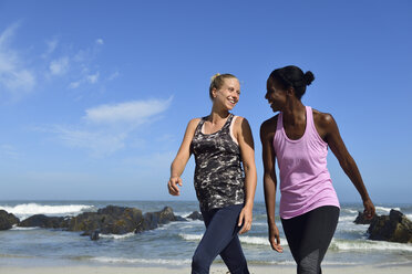 Two happy women walking on the beach - ECPF00461