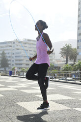 Sportive woman skipping rope outdoors - ECPF00483