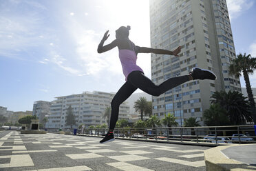 Sportliche Frau springt im Freien - ECPF00485