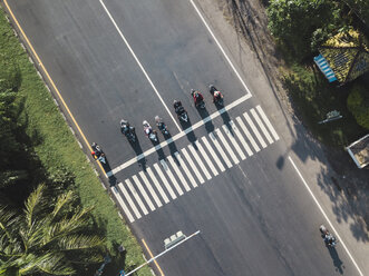 Indonesien, Bali, Sanur, Luftaufnahme von Motorrädern, die am Zebrastreifen auf der Straße warten - KNTF02663