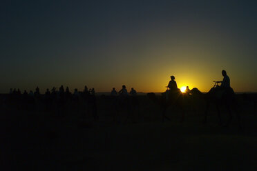 Morocco, people on camels at sunset - OCMF00279