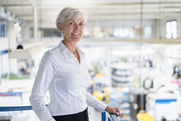 Porträt einer selbstbewussten älteren Geschäftsfrau im oberen Stockwerk einer Fabrik - DIGF05733