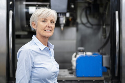Porträt einer selbstbewussten älteren Geschäftsfrau in einer Fabrik, lizenzfreies Stockfoto