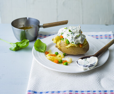 Gebackene Kartoffel mit Quark, Spargel, Erbsen und Möhren, lizenzfreies Stockfoto