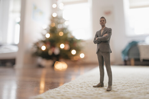 Geschäftsmann, der zu Hause neben einem Weihnachtsbaum steht, lizenzfreies Stockfoto