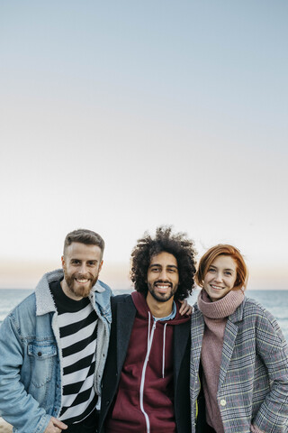 Porträt von drei glücklichen Freunden am Meer, lizenzfreies Stockfoto