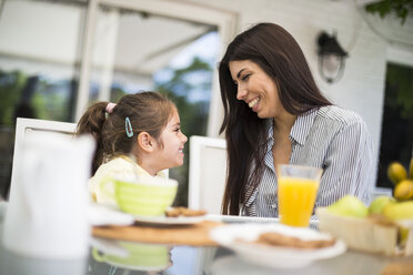 Happy mother and daughter having breakfast at home - ABZF02229