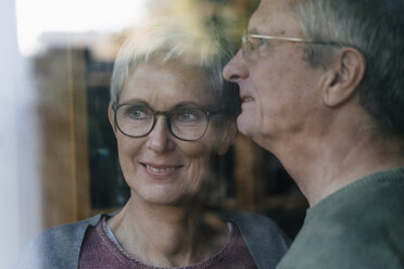 Confident senior couple looking out of window - KNSF05522