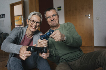Happy senior couple playing video game at home - KNSF05548