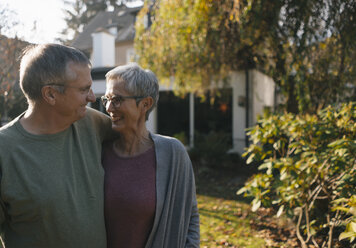 Affectionate senior couple embracing in garden - KNSF05556
